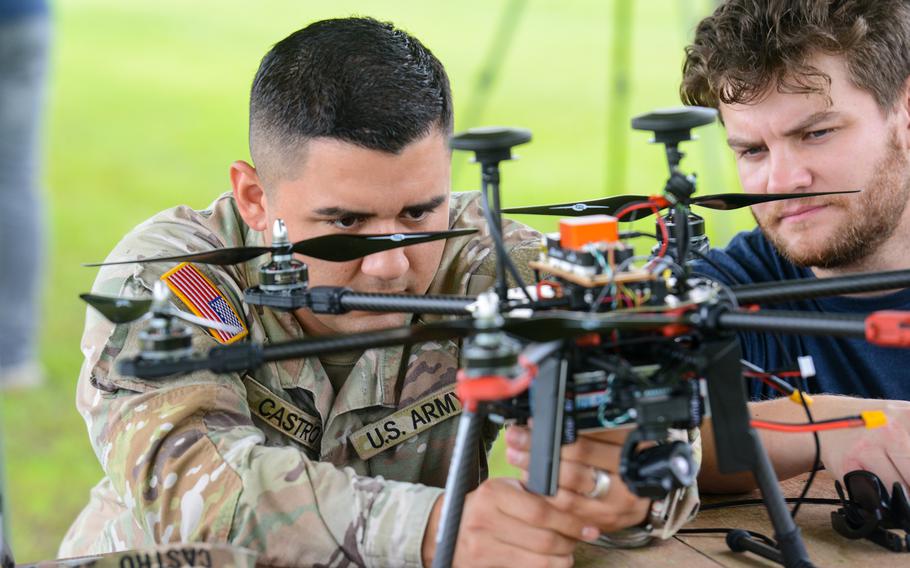 Army Pfc. Oscar Castro, left, and Henry Sullivan, the chief product officer with training firm Building Momentum, tinker with a hexacopter drone that Castro built just before a test flight at a Hinesville, Ga., airfield just outside Fort Stewart on July 26, 2024. Castro participated in a first-of-its-kind drone building class run by the division’s Marne Innovation Center at Fort Stewart. 