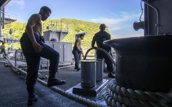 Sailors heave in the line on the fantail of the aircraft carrier USS Abraham Lincoln at Naval Base Guam on Aug. 8, 2024.