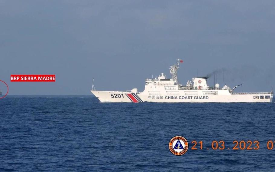 A Chinese coast guard vessels steams near the BRP Sierra Madre, a former U.S. Navy vessel grounded at Second Thomas Shoal in the South China Sea, March 21, 2023. 