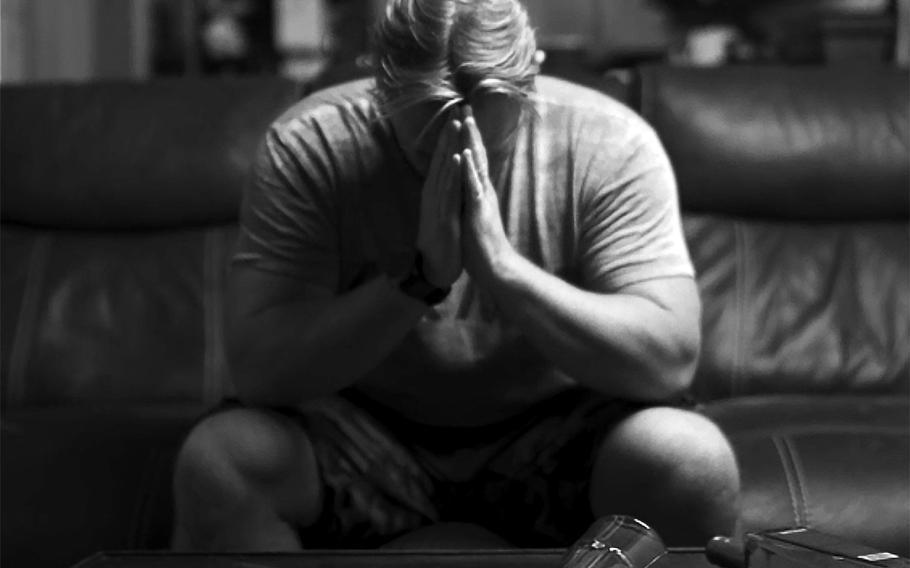 A man bows his head in deep contemplation