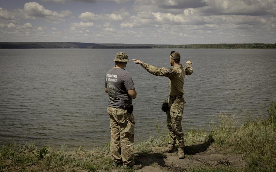 Vitalii, 23, and Roman, 35, soldiers in Ukraine’s 57th brigade, stand near a lake in Kharkiv region during a day off. 