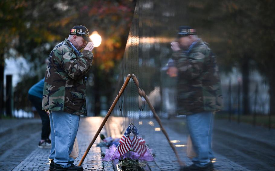 Bernie Klemanek throws a salute while visiting the Vietnam Veterans Memorial.