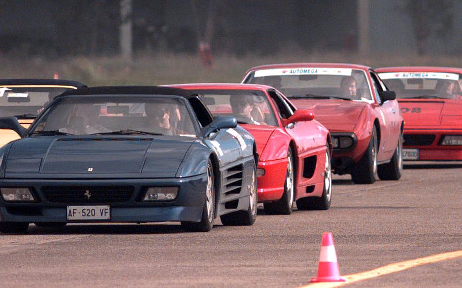 A pack of Ferraris zooms down a course set up along a taxiway at Naval Air Station Sigonella in November 1997. In all, 34 Ferraris were on display for a show commemorating the 50th anniversary of Ferrari in Sicily.