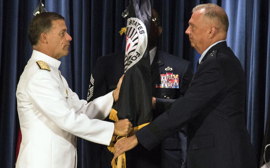 Adm. John Aquilino, the head of Indo-Pacific Command, passes the guidon to the new commander of U.S. Forces Japan and 5th Air Force, Lt. Gen. Ricky Rupp, at Yokota Air Base, Japan, Friday, Aug. 27, 2021.