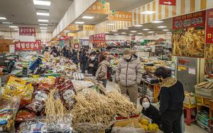 Customers peruse items on tables at a South Korean market.