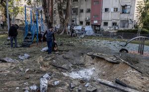 People last week investigate a crater in a Tel Aviv neighborhood left by a missile launched from Yemen. MUST CREDIT: Heidi Levine for The Washington Post