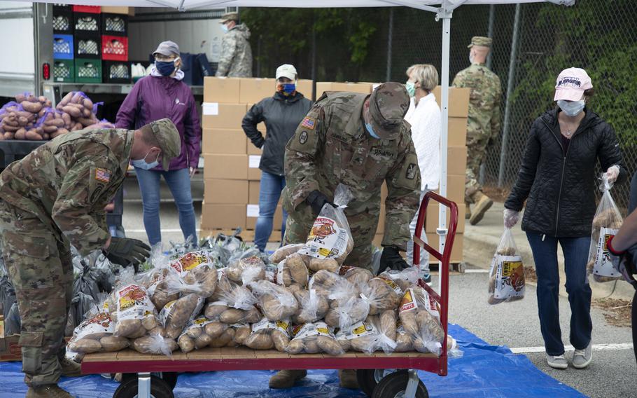 North Carolina Army National Guard soldiers and other volunteers stack bags of potatoes that were being distributed to veterans and military families in May 2020. 