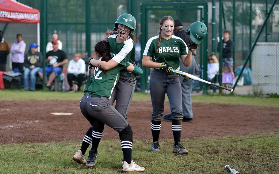 Naples' Ariana Lopez, left, and Madisun Myers celebrate after teammate Anna Gose, right, scored the final run during the Division II/III DODEA European softball championship game against Rota on May 24, 2024, at Kaiserslautern High School in Kaiserslautern, Germany.