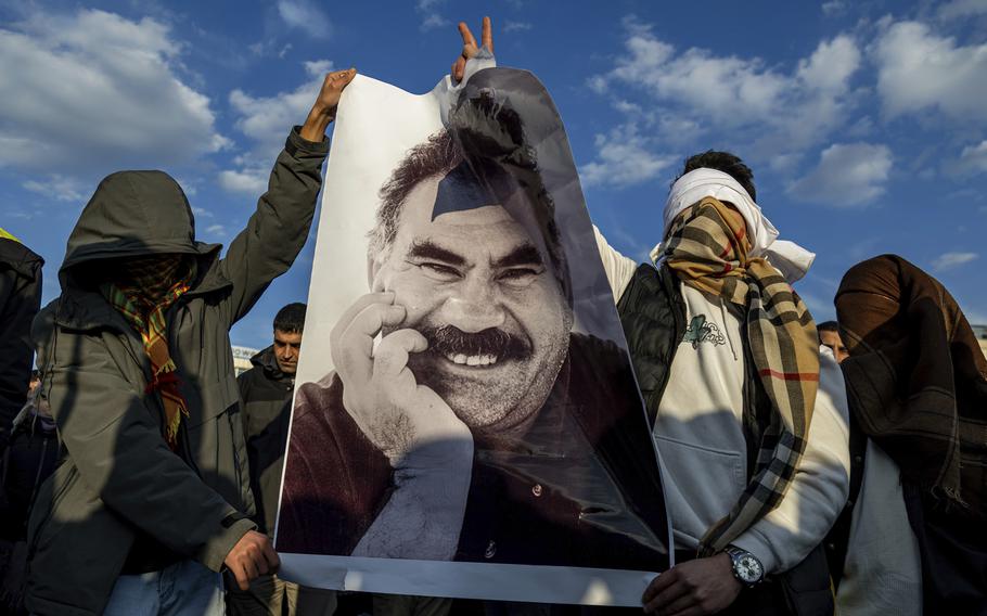 Youngsters hold a photograph of the jailed leader of the rebel Kurdistan Workers’ Party, or PKK, Abdullah Ocalan as they gather to watch live on a tv screen a Pro-Kurdish Peoples’ Equality and Democracy Party, or DEM, delegation members releasing an statement from Ocalan, in Diyarbakir, Turkey.