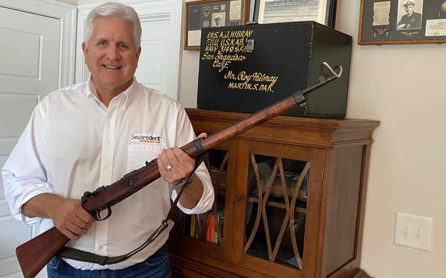 Blake Hibray showcases his father’s Navy footlocker and souvenir Japanese military rifle. 