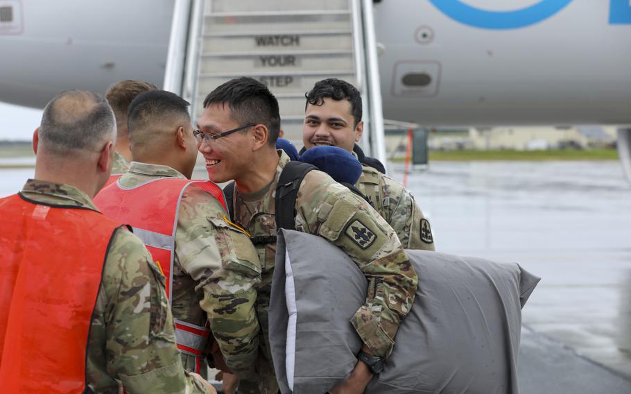 Alaska Army National Guard Capt. Andrew Viray, commander of Alpha Company, 1st Battalion, 297th Infantry Regiment, welcomes back Spc. Wilson Berlin, right, an infantryman with Bravo Company, 1-297th Inf., at the flight line of Joint Base Elmendorf-Richardson, Alaska, Aug. 10, 2024, after a nine-month deployment to Kuwait. 