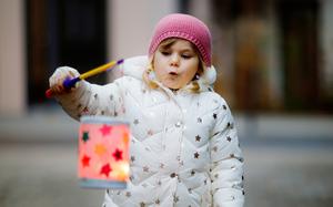 A small girl holds a homemade lantern during a St. Martin procession in Germany. Celebrations in the saint’s honor take place in Germany and elsewhere on or near Nov. 11.