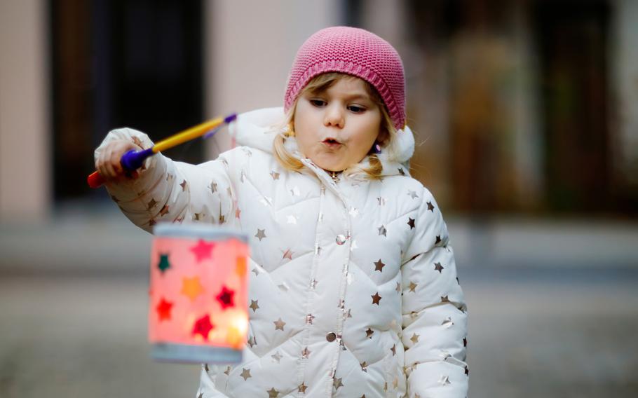 A small girl holds a homemade lantern during a St. Martin procession in Germany. Celebrations in the saint’s honor take place in Germany and elsewhere on or near Nov. 11.