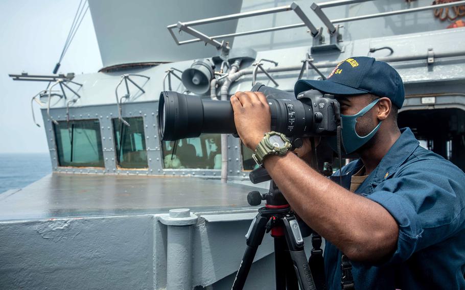 Intelligence Specialist Chief Michael Tolbert stands watch on the bridge of the guided-missile destroyer USS Curtis Wilbur as it transits the Taiwan Strait, May 18, 2021.