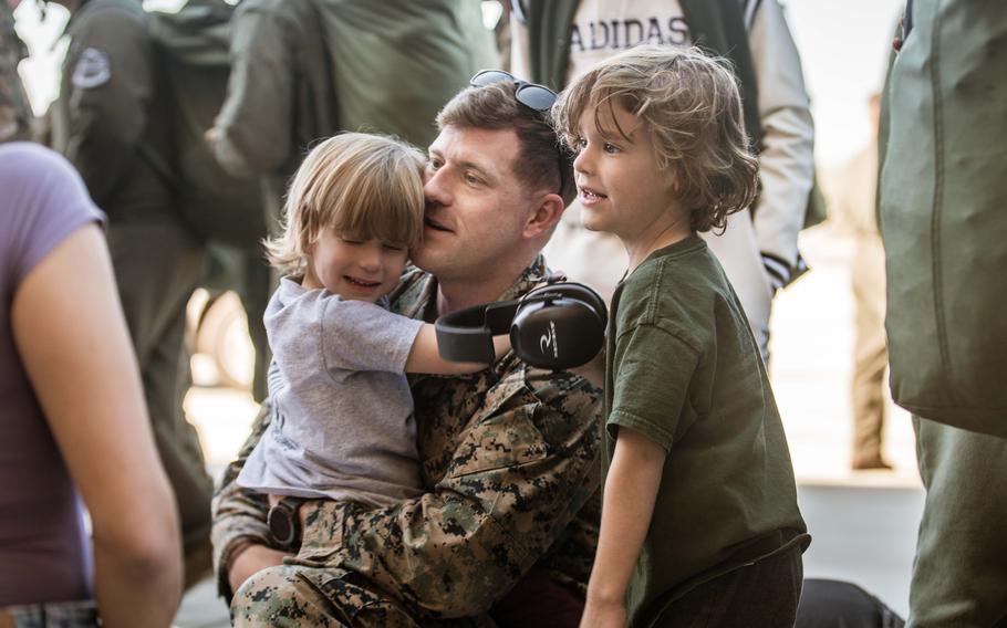 Marine hugs his son