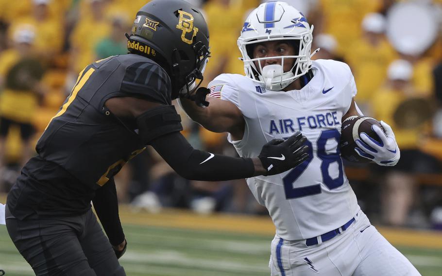 Air Force running back Aiden Calvert stiff-arms Baylor linebacker Keaton Thomas 