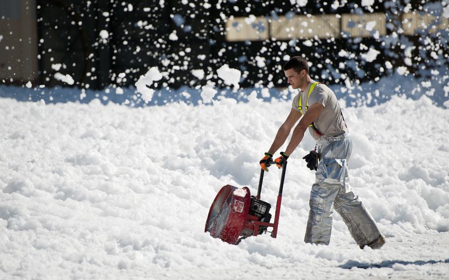 Personnel clean up fire-retardant foam “unintentionally released” in an aircraft hangar at Travis Air Force Base in California on Sept. 24, 2013.