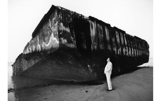 Arromanches-les-Bains, France, May, 1994: Fifty years after the allied invasion of Normandy in World War II, a visitor looks up at the remnants of one of the "Phoenix" concrete caissons used in the construction of an artificial harbor that allowed supplies to flow to the troops as they moved inland. 

Check out what will be happening on the Normandy beaches this year for D-Day's 80th anniversary on our Europe Community paper's D-Day page here.
https://europe.stripes.com/d-day/

META TAGS: DDAY80; Normandy; D-Day; WWII; World War II