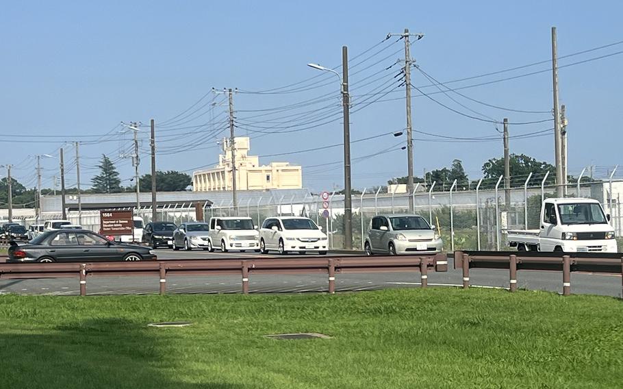 Vehicles wait to cross a portion of the runway at Yokota Air Base, Japan, Monday, July 10, 2023. 