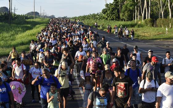 Migrants walk along the highway through Suchiate, Chiapas state in southern Mexico, Sunday, July 21, 2024, during their journey north toward the U.S. border.