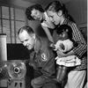 Maj. James S. LiCalzi, an explosive ordnance disposal officer with the 30th Ordnance Bomb Disposal Squadron, sets up his reel to reel tape player as his wife Frances and daughter Pamela look on. 