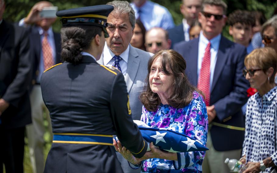 A member of the Connecticut National Guard funeral honors team presents the American Flag to the family of Tech Sgt. Kenneth McKeeman during his burial at the Connecticut State Veterans Cemetary in Middletown, Conn., June 7, 2024. 