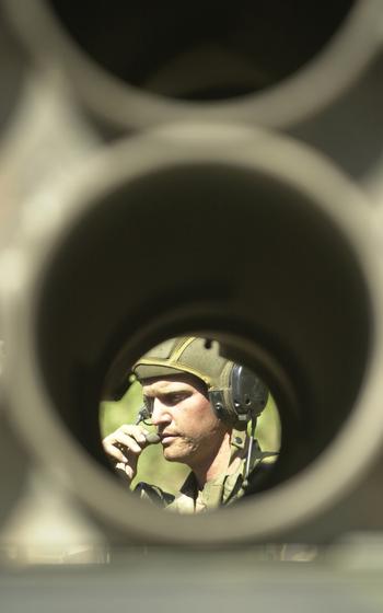 A gunner checks the empty pods of the Multiple Launch Rocket System (MLRS) vehicle.