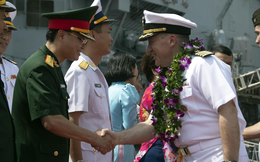 Capt. Daryle Cardone, commander of the aircraft carrier USS Ronald Reagan, greets Vietnamese navy sailors during a welcome ceremony in Da Nang, Vietnam, Sunday, June 25, 2023.