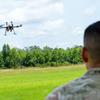 A 3rd Infantry Division soldier watches as a small drone built in a drone-building class at Fort Stewart, Ga., flies over a small airfield just off the Army post on July 26, 2024. (Corey Dickstein/Stars and Stripes)