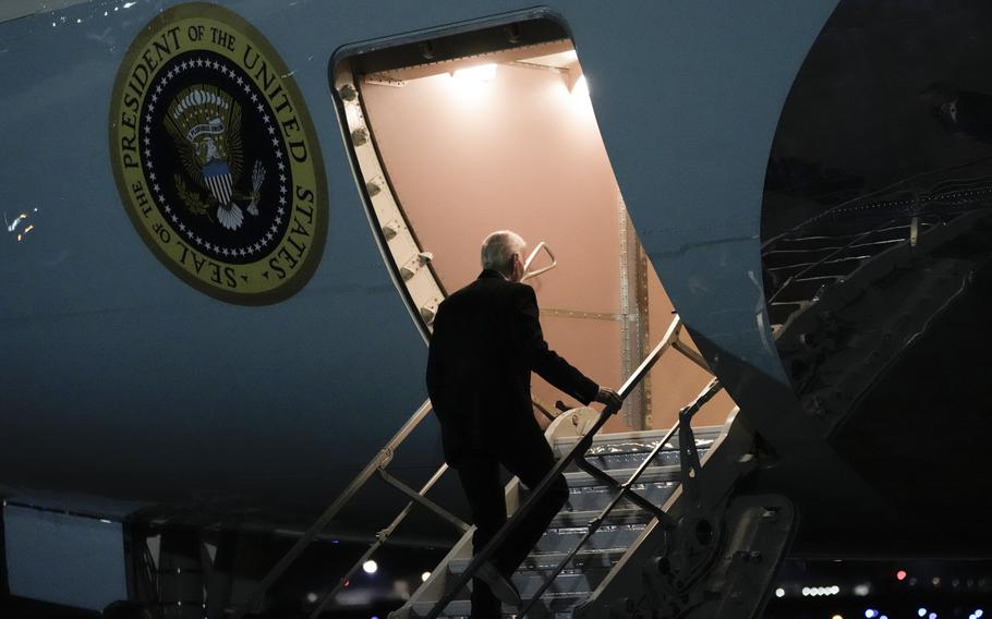 President Joe Biden walks up the stairs to board the Air Force One plane.