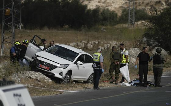 Israeli security forces and rescue services check the scene of a shooting attack in the West Bank city of Tarkumiya, Sunday, Sept. 1, 2024. Israeli authorities said Palestinian gunmen killed several Israelis in a shooting attack in the occupied West Bank. Israel has been carrying out large-scale military raids in the territory in recent days. (AP Photo/Mahmoud Illean)