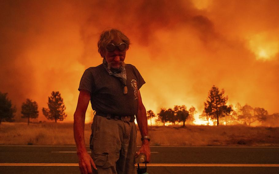 Grant Douglas pauses while evacuating as the Park Fire jumps Highway 36 near Paynes Creek in Tehama County, Calif., on Friday, July 26, 2024. 