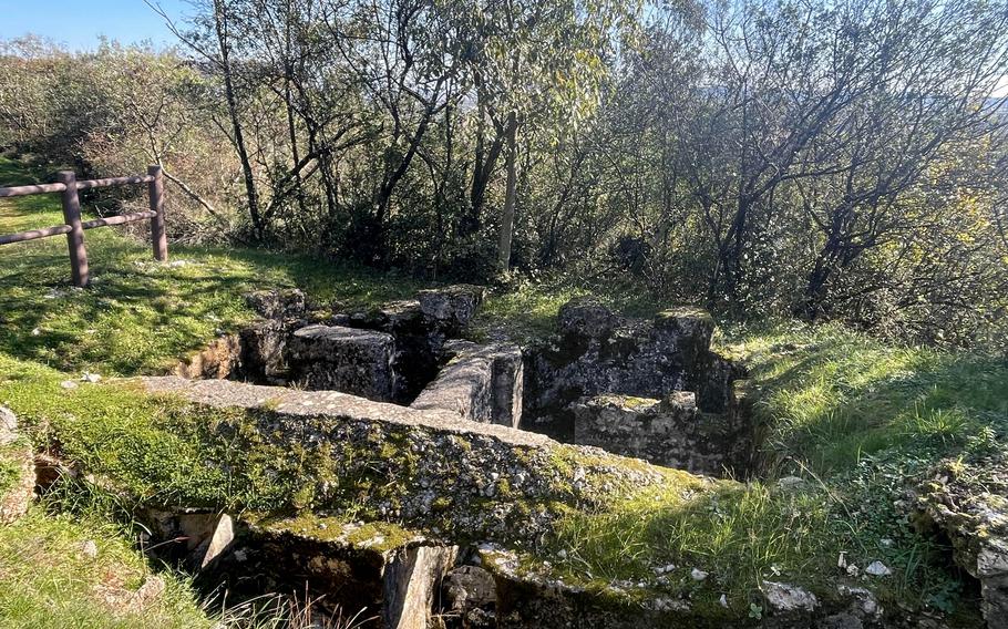 A reinforced old trench sites between grassy areas.