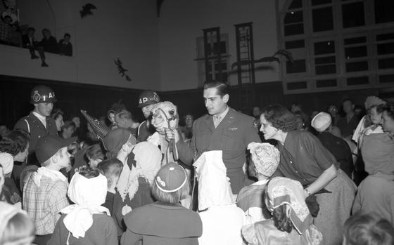 Children - donned in their best Halloween costumes - are eager to pet "Clarence the Camel," the mascot of the pilots of the 86th Fighter Group and donate some of their candy to the children of Berlin, so that Clarence can ferry them to the blockaded city on his own C47 Operation Vittles flight. 

The camel was bought in August 1948 in Libya by Lt. Donald Butterfield - seen here with Clarence. Clarence soon became a mascot for Operation Vittles - also known as the Berlin Airlift - as people would deposit gifts and candy for the Berlin children in the camel's saddlebags during football games on the 86th Neubiberg Air Base, as well as other events across West German U.S. bases.