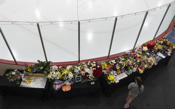 A memorial is seen along the boards at MedStar Capitals Iceplex Sunday, Feb. 2, 2025, in Arlington, Va., for the figure skaters who were among the 67 victims of a mid-air collision between an Army helicopter and an American Airlines flight from Kansas. (AP Photo/Carolyn Kaster)