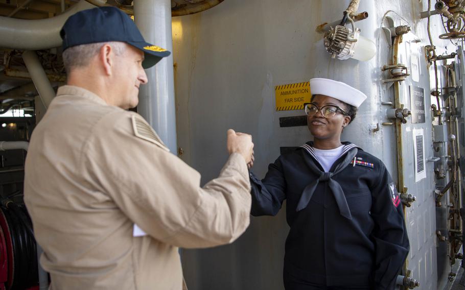 Rear Adm. Ted LeClair, deputy commander, Naval Surface Forces, U.S. Pacific Fleet, gives a fist-bump to Personnel Specialist 2nd Class Ajetokunbo Akinmoluwa.