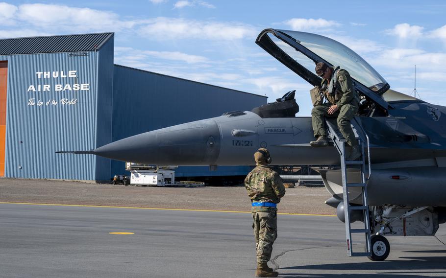 A pilot disembarks from a jet at Thule Air Base, Greenland.