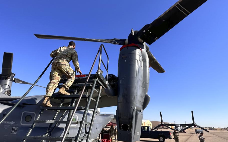 Master Sgt. Frank Williams climbs up a portable stairway to show where checks have to be performed after an Osprey flight.