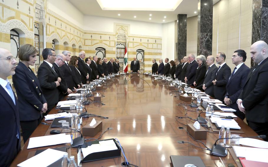 In this photo released by the Lebanese Government, Lebanese President Joseph Aoun, center background, new Lebanese Prime Minister Nawaf Salam, left background, and ministers of the new government observe a minute of silent for the victims of the war between Israel and Hezbollah before their first meeting at the presidential palace, in Baabda, east of Beirut, Lebanon, Tuesday, Feb. 11, 2025. 