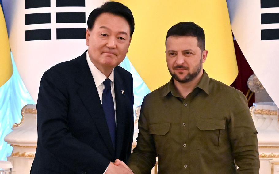 Ukrainian President Volodymyr Zelenskyy, right, and shakes hands with his South Korean counterpart Yoon Suk Yeol during talks in Kyiv in July 2023.