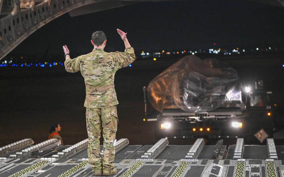 Airman directs an airman loading U.S. Army luggage onto a C-17 Globemaster III