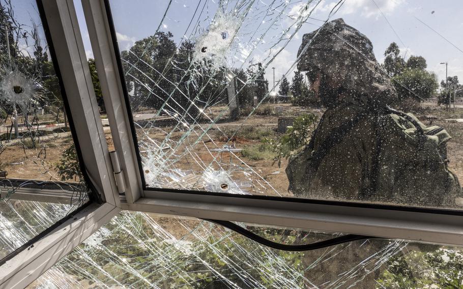 An Israeli soldier passes a family’s home riddled with bullet holes in Kibbutz Kissufim, Israel, on Oct. 18. Hamas militants attacked the kibbutz on Oct. 7, 2023.