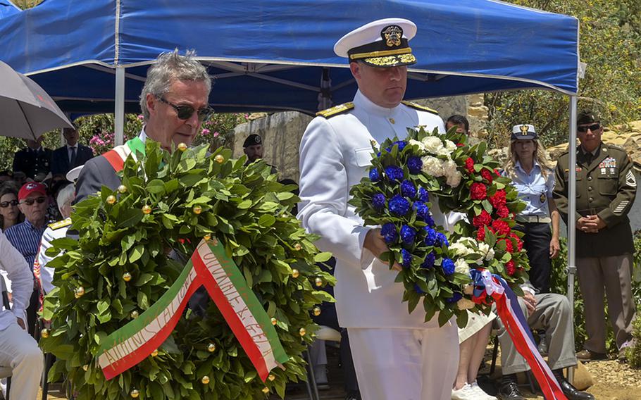 Rear Adm. Brad Collins, commander of Navy Region Europe, Africa, Central, right, and Lucio Greco, mayor of Gela, Italy, present commemorative wreaths at an Operation Husky 80th anniversary ceremony, at the 82nd Airborne Division Monument at Ponte Dirillo on July 10, 2023. 