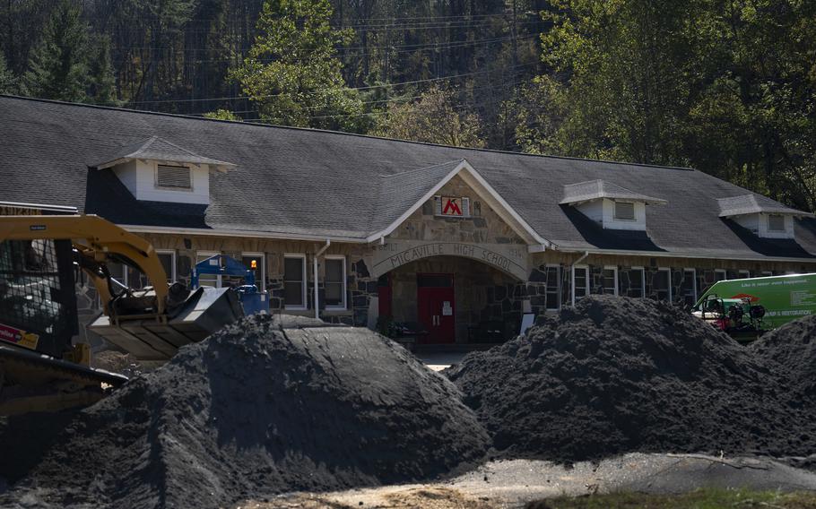 Piles of dirt surround the entrance of a high school.