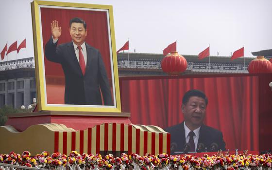 FILE - Participants cheer beneath a large portrait of Chinese President Xi Jinping during a parade to commemorate the 70th anniversary of the founding of Communist China in Beijing, Tuesday, Oct. 1, 2019. (AP Photo/Mark Schiefelbein, File)