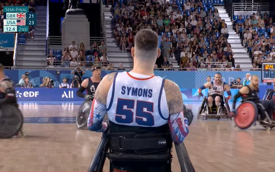 Army veteran Mason Symons surveys the scene before throwing a pass during the USA’s 50-43 victory over Great Britain in a wheelchair rugby semifinal match at Champ-de-Mars Arena in Paris.