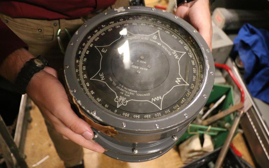 Battleship New Jersey museum curator Ryan Symanski displays a gyrocompass repeater on July 13, 2021.