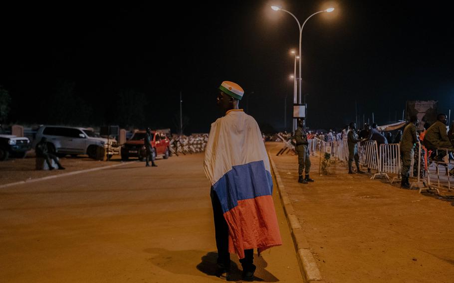 A man is wrapped in a Russian flag while attending a concert in Niamey, Niger, on Oct. 14. 