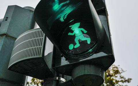 A close-up of the green Betzi pedestrian signal shows the 1. FC Kaiserslautern mascot lighting the way for walkers at an intersection in Kaiserslautern, Oct. 15, 2024. The unique lights are part of a city initiative celebrating local soccer pride. 