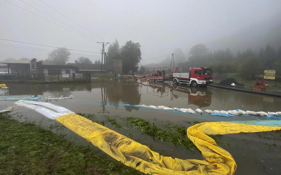 Firefighters pump water and mud from city streets and help clean the city of Głogow after it was hit by a high flood wave, in Głogow, southwestern Poland, on Wednesday, Sept. 18, 2024.